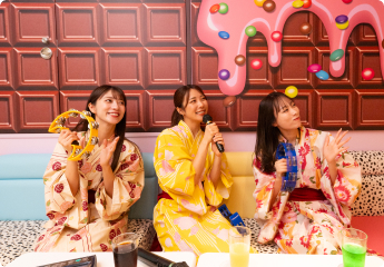 写真:カラオケで歌う女性達