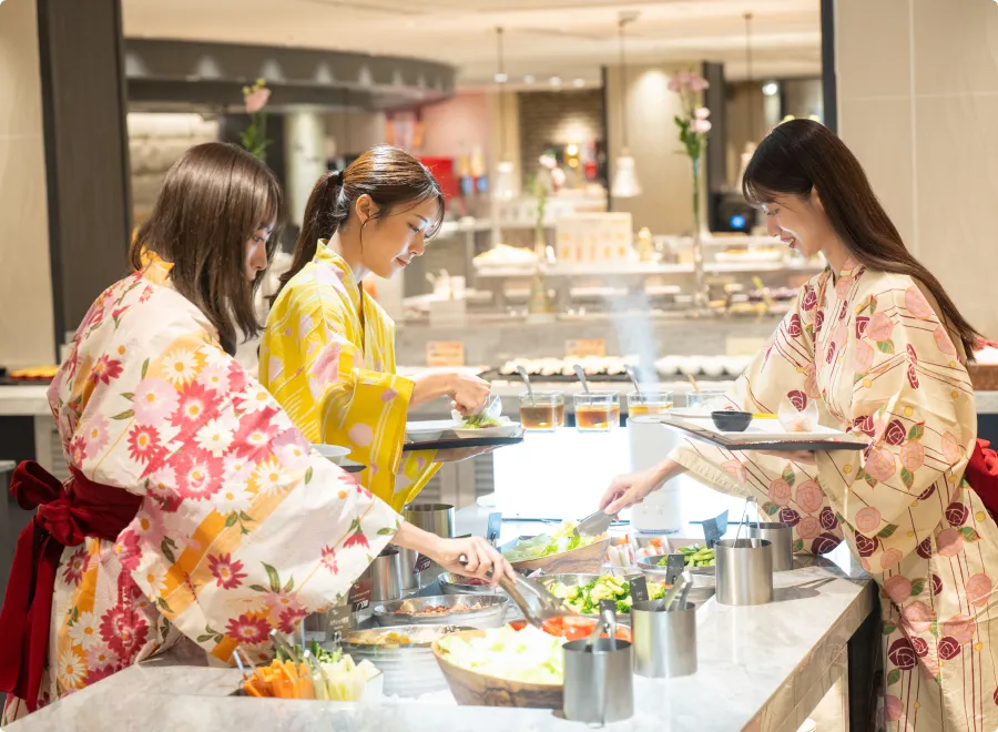 写真:ブッフェで料理をとる女性達