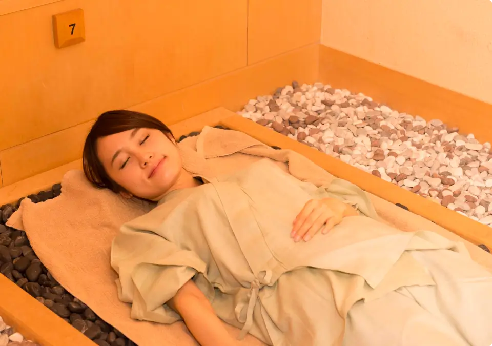 写真:岩盤浴をする女性